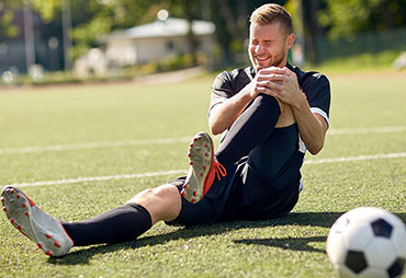 Male soccer player in pain with knee injury