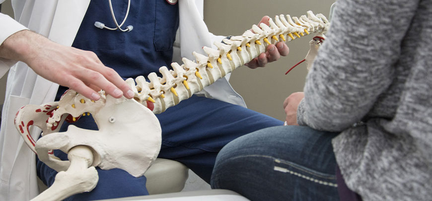 Chiropractor discussing spine misalignments with patient